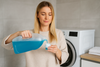 An image of a woman measuring out laundry detergent
