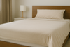 An image of a bed with bedsheets