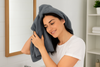 An image of a woman using a microfiber towel on her hair