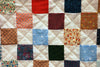 A stitched quilt hanging up after being washed