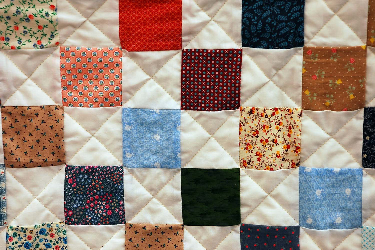 A stitched quilt hanging up after being washed