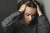 Woman holding head showing stress and lack of sleep