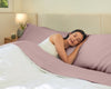 An image of a lady sleeping on sheets