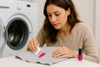 An image of a woman cleaning nail polish off clothes