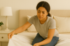 An image of a woman wondering why her bed sheet comes off