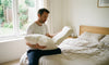 A man holding two pillows and comparing them.