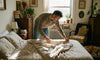 A man inspecting. the bedsheet for stains.