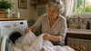 Grandma putting the bedsheet on the washing machine.