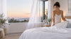 A woman fixing the bed sheet.