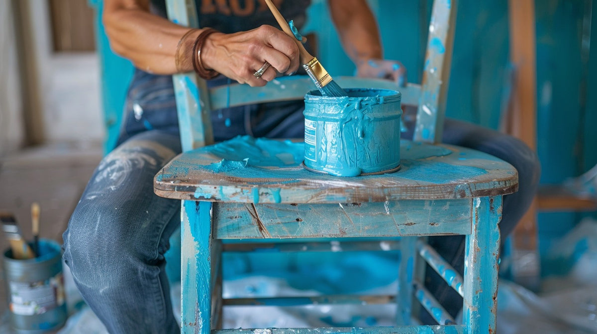 An image of someone painting a chain with paint stains on their clothing