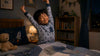An asian kid stretching before going to sleep.