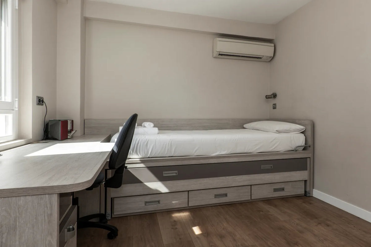 Space-saving trundle bed with built-in drawers and desk