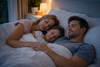 A family sleeping together on the bed.