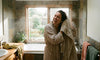 A woman drying her hair using a bath sheet.