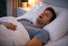 A man snoring while asleep.
