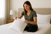 Woman holding a white pillow on the white bed