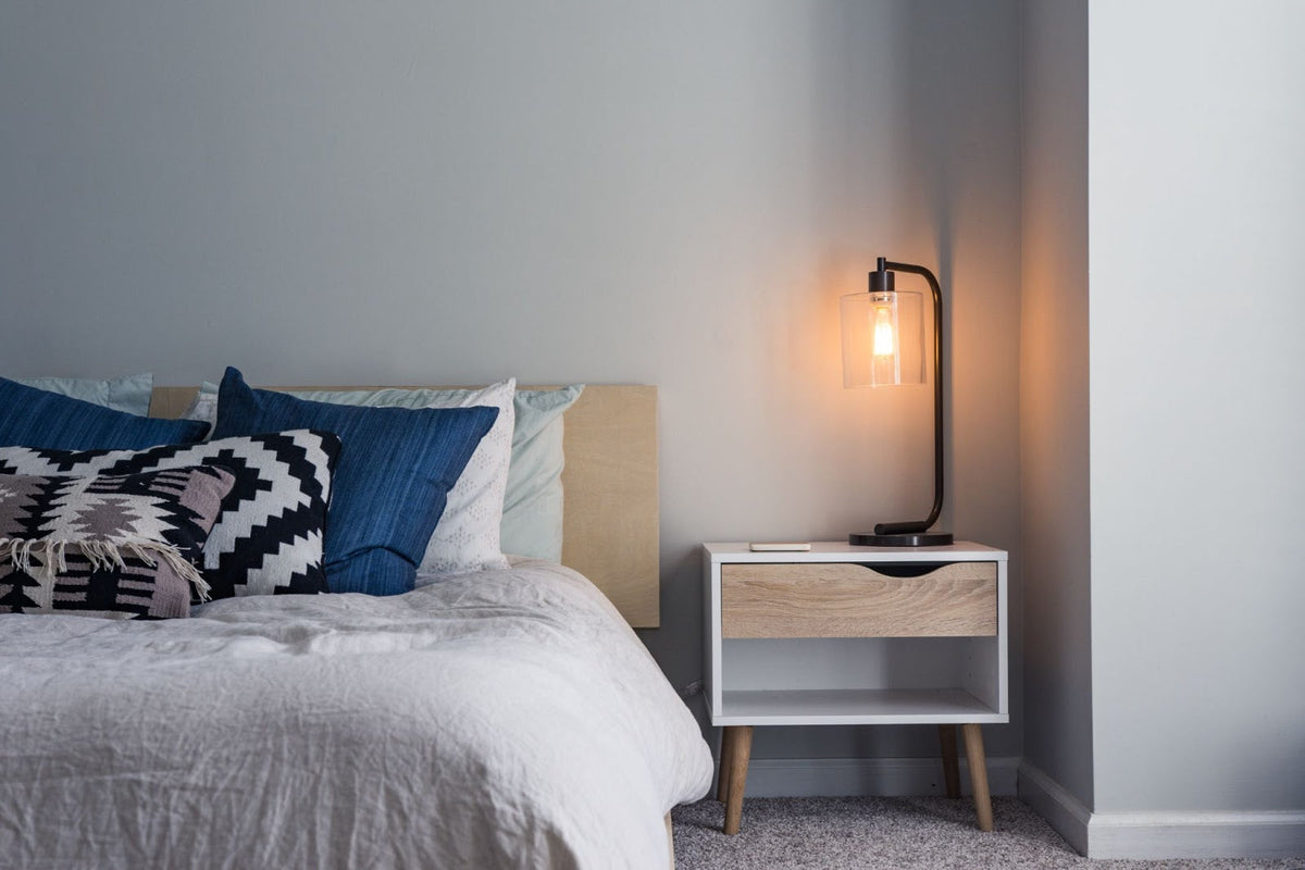 A mattress and blue pillows in a dimly lit room