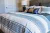 Modern bed with soft down comforter and patterned bedding
