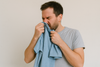 A man smelling his t-shirt.