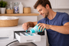A man putting scent beads in the washing machine.