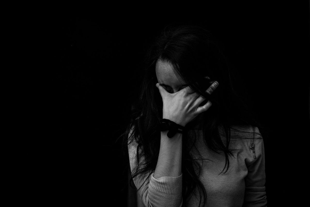 An anxious woman covering her face with her hand.