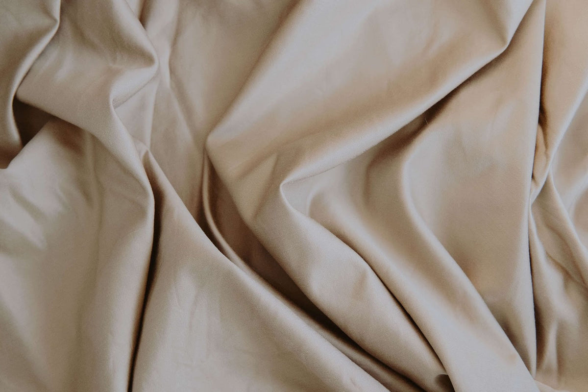 Beige sheets on a bed.