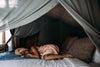 Woman sleeping peacefully on soft bed with breathable bedding