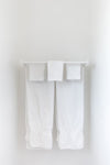 White bath towels hanging on a white bar.