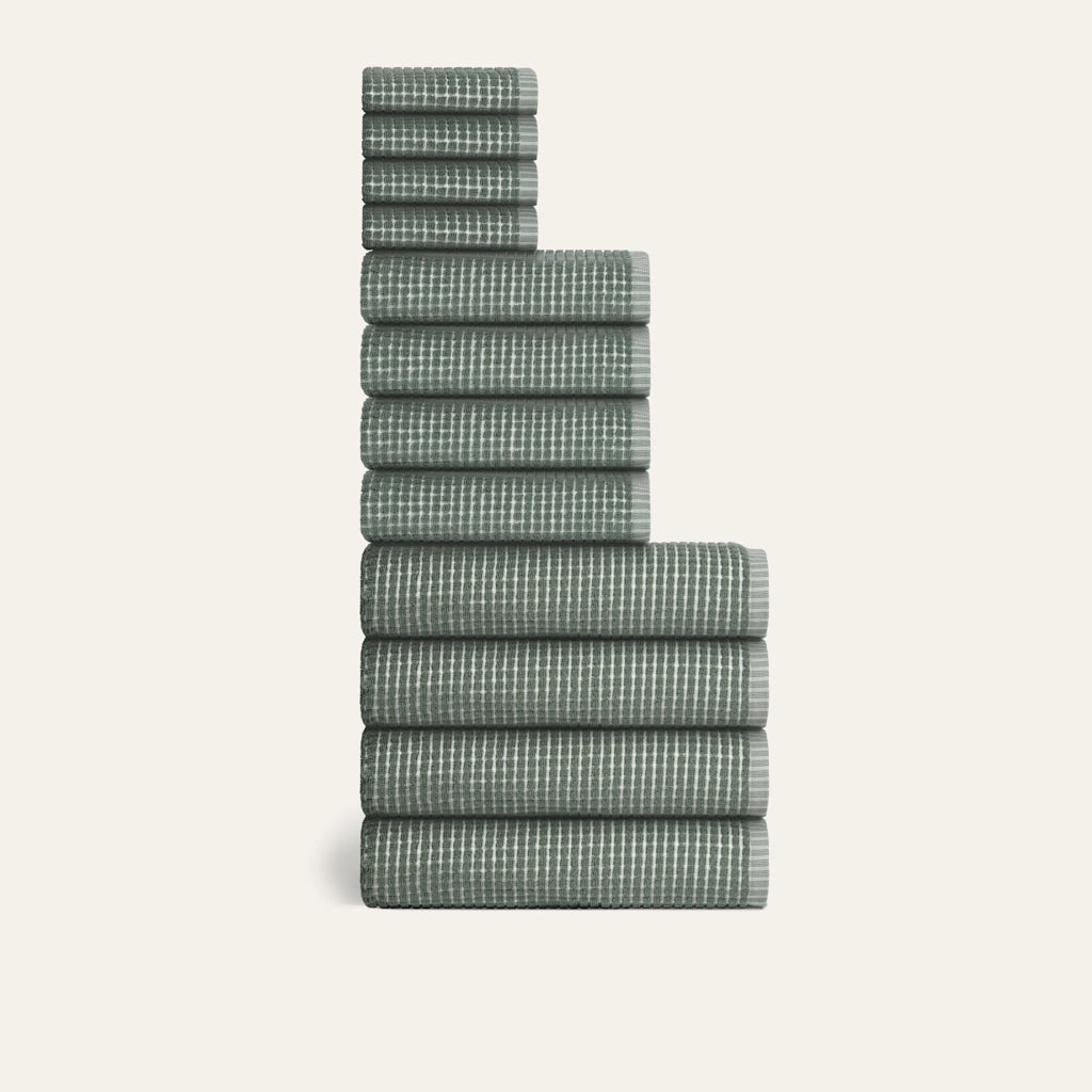 Stack of green checkered towels on a white background