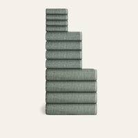 Stack of green checkered towels on a white background