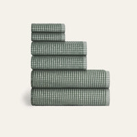 Stack of green checkered towels on a white background