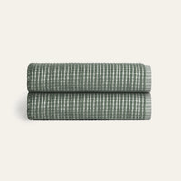 Two folded textured towels on a light beige background