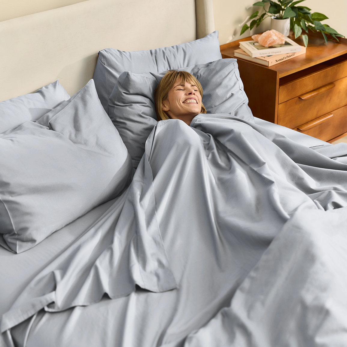 Grey sheets on a neatly made bed