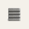 Stack of four gray textured towels on a light gray background