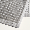 Gray textured bath mat with 'Onsen' branding on a white background