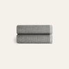 Two folded gray textured towels on a light beige background