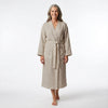 Woman wearing a beige robe on a white background