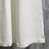 White textured shower curtain against a neutral wall