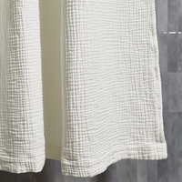 White textured shower curtain against a neutral wall
