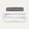 White comforter and gray pillow on a white background