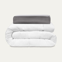 White comforter and gray pillow on a white background