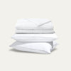 Stack of white bedding on a light gray background