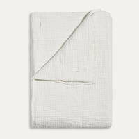 Folded light gray textured blanket on a white background