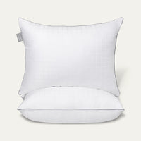 White pillow with a gray tag on a light gray background