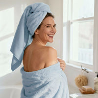 Woman wrapped in a blue towel in a bathroom