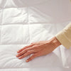 Hand touching a white quilted surface