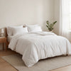 Neatly made bed with white bedding in a bedroom setting.