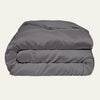Folded gray comforter on a beige background