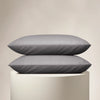 Two gray pillows stacked on a beige pedestal against a beige background