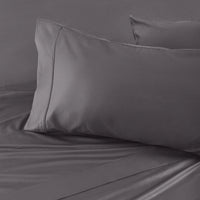 Gray bedding set with two pillows on a bed.